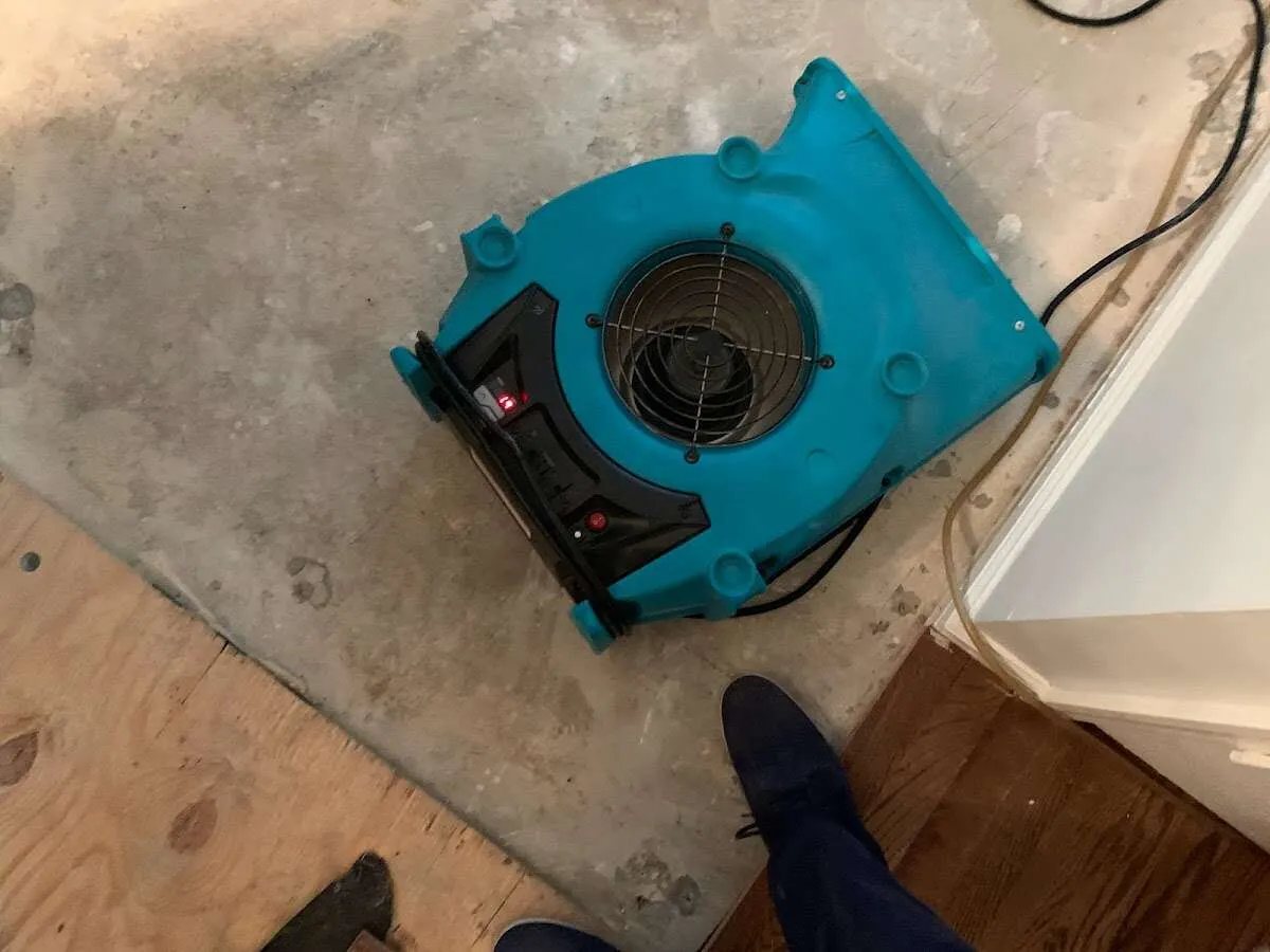 Air mover drying subfloor during Leak Detection & Repair in East Rockaway